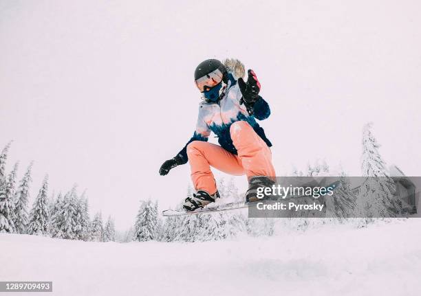 snowboarder jumps with snow dust - freestyle snowboarding stock pictures, royalty-free photos & images