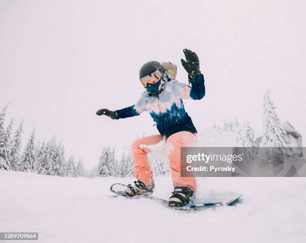 snowboarder jumps with snow dust - radical snowboarding stock pictures, royalty-free photos & images