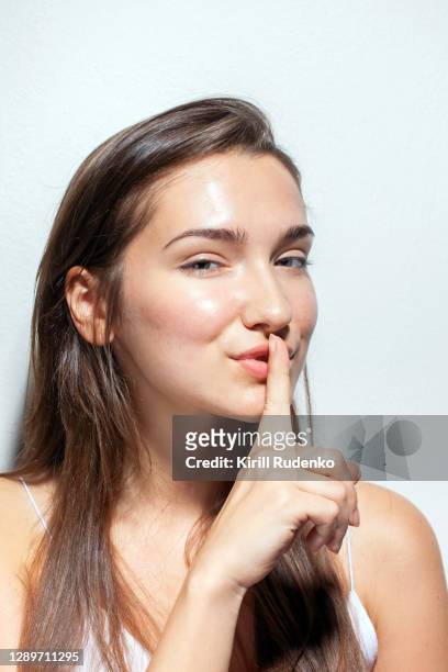 young woman shushing with finger up to mouth - beautiful czech women 個照片及圖片檔