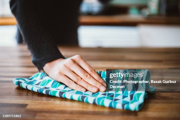 close-up of woman hand cleaning the surface of a table with a cleaning cloth at home - straccio da cucina foto e immagini stock