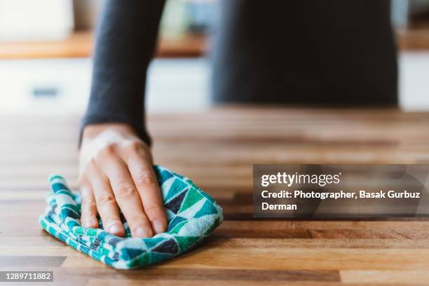 close-up of woman hand cleaning the surface of a table with a cleaning cloth at home - clean surface stock pictures, royalty-free photos & images