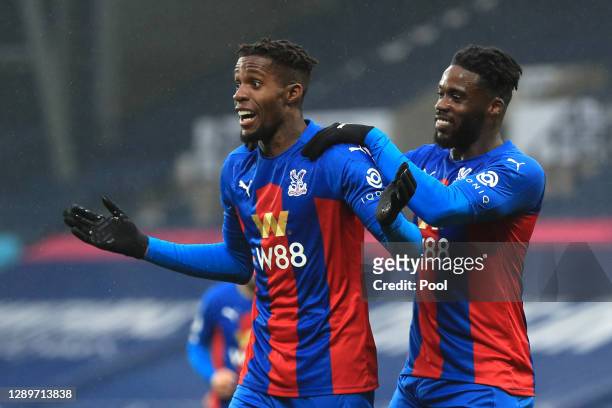 Wilfried Zaha of Crystal Palace celebrates with Jeffrey Schlupp after scoring their team's fourth goal during the Premier League match between West...