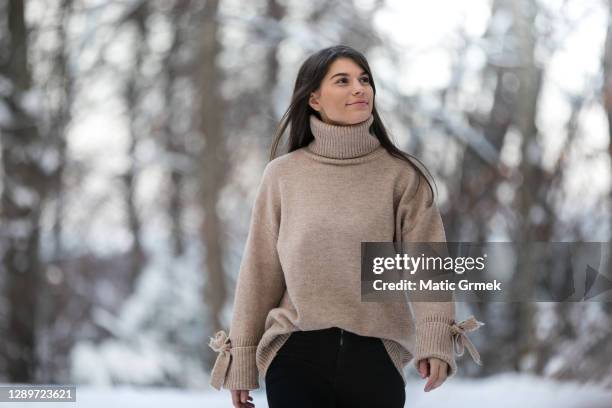 retrato de mujer joven de pelo largo, con chaqueta blanca y manoplas posando en día soleado de invierno. - jersey de cuello alto fotografías e imágenes de stock