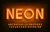 Neon alphabet font. 3D neon light letters and numbers. Brick wall background.