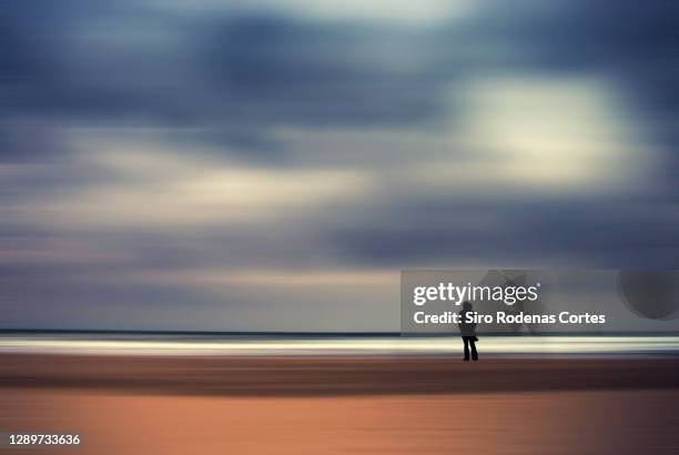 silhouette of a woman on the beach symbolizing tranquility and relaxation - backgrounds people imagens e fotografias de stock