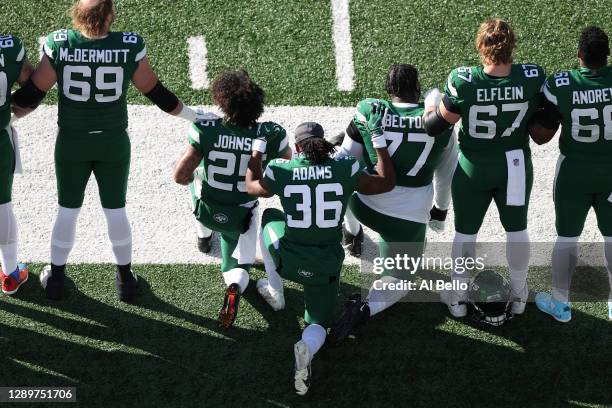 Ty Johnson, Josh Adams, and Mekhi Becton of the New York Jets kneel for the National Anthem before the game against the Las Vegas Raiders at MetLife...