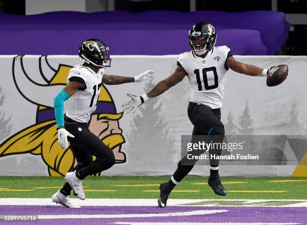 Laviska Shenault Jr. #10 of the Jacksonville Jaguars celebrates his touchdown with teammate D.J. Chark in the first quarter against the Minnesota...