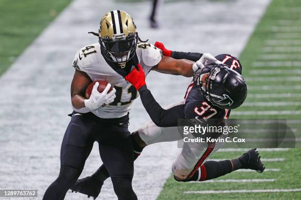 Alvin Kamara of the New Orleans Saints pushes offsides Ricardo Allen of the Atlanta Falcons during the second quarter at Mercedes-Benz Stadium on...