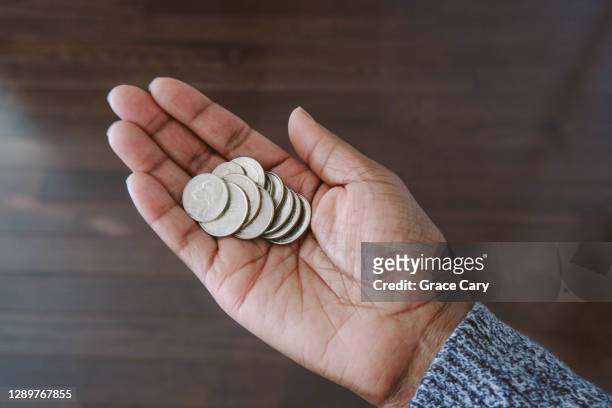 woman holds change in palm of hand - us coin 個照片及圖片檔
