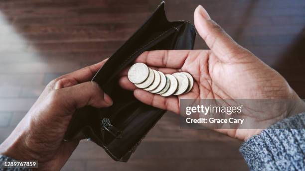 woman holds us coins in palm of hand - coin in palm of hand stock pictures, royalty-free photos & images