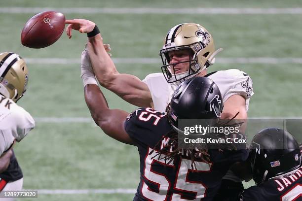 Steven Means of the Atlanta Falcons forces a fumble by Taysom Hill of the New Orleans Saints during the fourth quarter at Mercedes-Benz Stadium on...