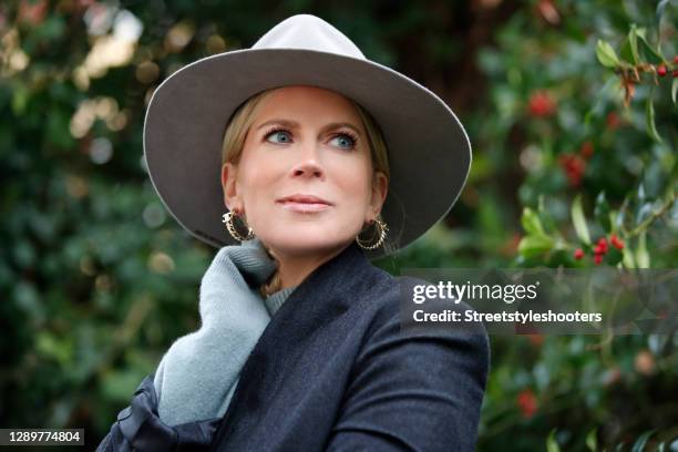 German TV host Tamara von Nayhauss wearing a grey hat, a grey turtleneck pullover by Loulou Studio, a black and grey blazer by Loulou Studio and gold...