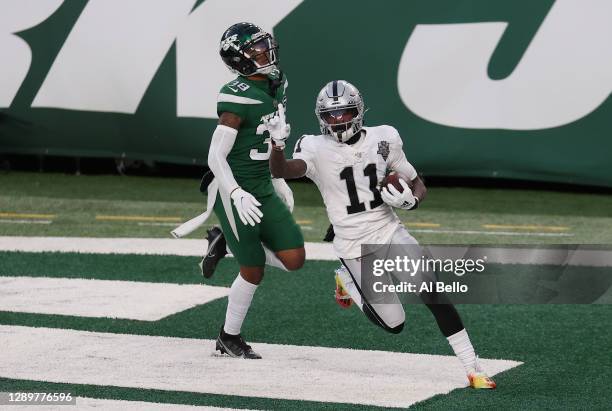 Henry Ruggs III of the Las Vegas Raiders reacts after scoring a touchdown in the final seconds of the second half as Lamar Jackson of the New York...