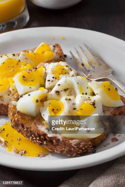 perfect soft boiled eggs on buttered toast with fresh cracked pepper - boiled egg stock pictures, royalty-free photos & images