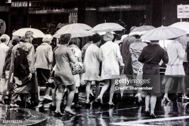 old photo from sixties, people with umbrelas in rainy day in the city,  australia - 60's stock pictures, royalty-free photos & images