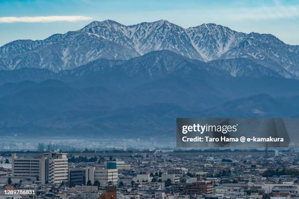 snowcapped tateyama mountains and toyama city in toyama prefecture of japan - toyama prefecture stock-fotos und bilder