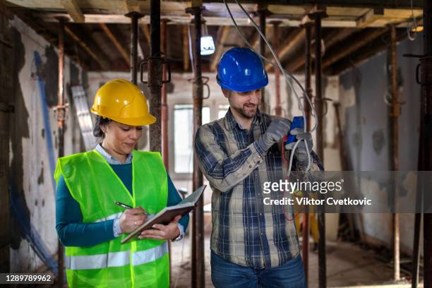 jonge elektroingenieurvrouw en mannelijke elektricien - man cutting wire stockfoto's en -beelden