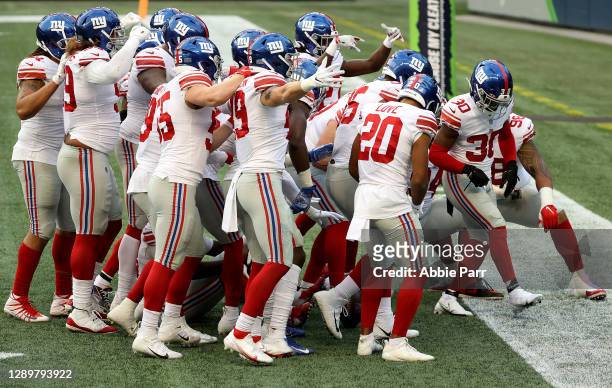 Darnay Holmes of the New York Giants celebrates with his teammates after intercepting a pass thrown by Russell Wilson of the Seattle Seahawks during...