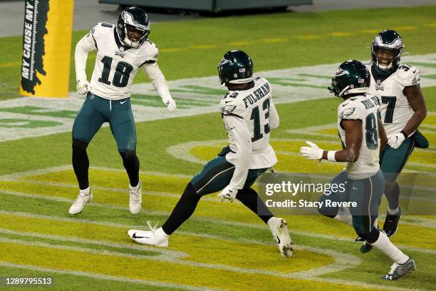 Jalen Reagor of the Philadelphia Eagles celebrates with teammates Travis Fulgham and Greg Ward following a punt return for a touchdown during the...