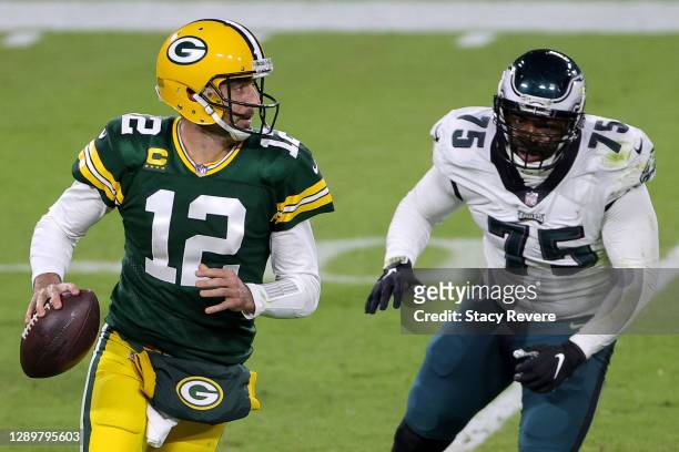 Aaron Rodgers of the Green Bay Packers scrambles to avoid a tackle from Vinny Curry of the Philadelphia Eagles during the fourth quarter of their...