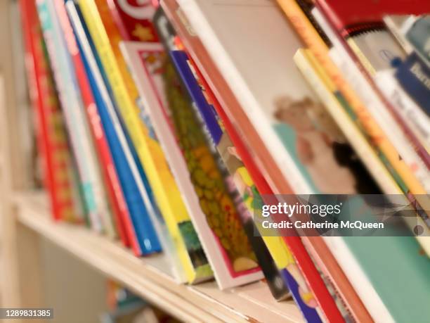 bookshelf loaded with children’s books in toddler girl’s bedroom - story book stock-fotos und bilder