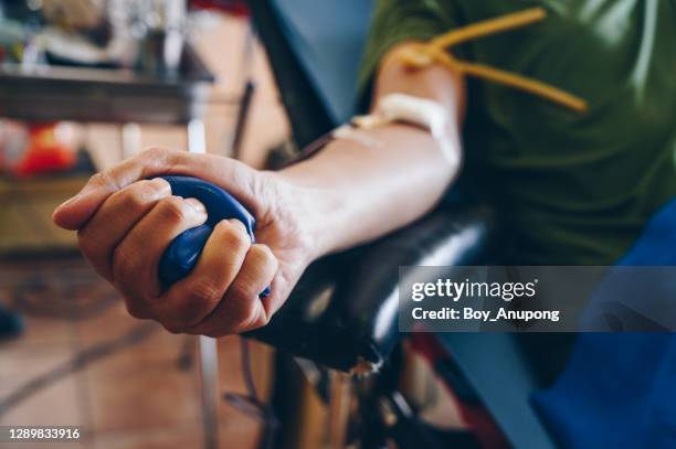 cropped shot of someone squeeze a squish ball while donating blood. - donate stock-fotos und bilder