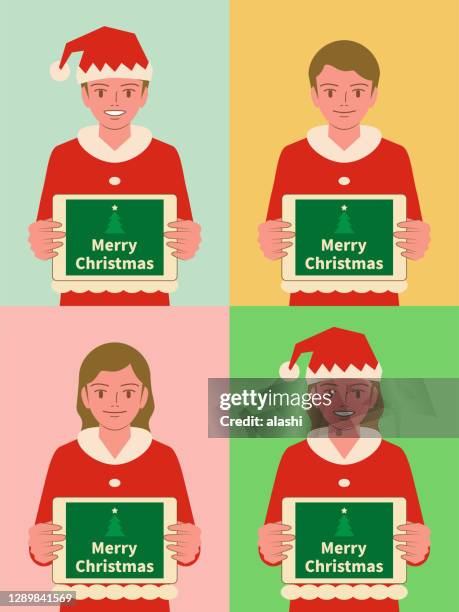 smiling beautiful children (boys and girls) dressed in a santa claus suit holding a digital tablet - asian child ipad stock illustrations