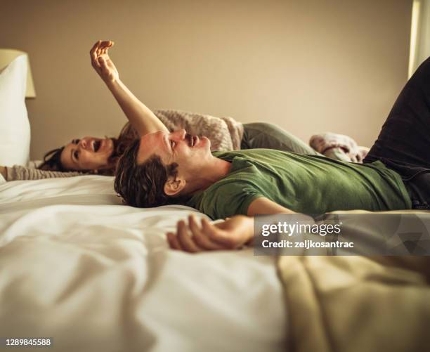 de ouders en de zoon zitten op bed in hotelkamer - hotelroom stockfoto's en -beelden