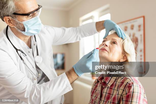 swab test to a female patient - world health organization stock pictures, royalty-free photos & images