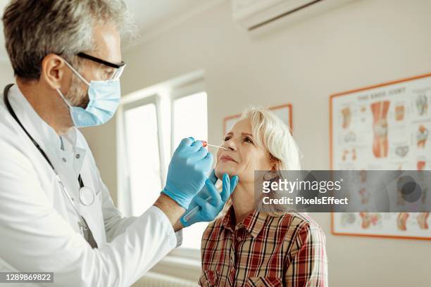 swab test to a female patient - world health organization stock pictures, royalty-free photos & images