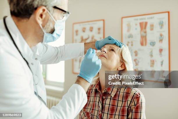 swab test to a female patient - world health organization stock pictures, royalty-free photos & images