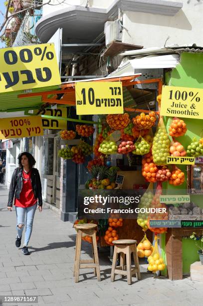 Jeune femme passant près d'une échoppe de jus de fruits sur King George street le 26 février 2019 à Tel Aviv, Israël