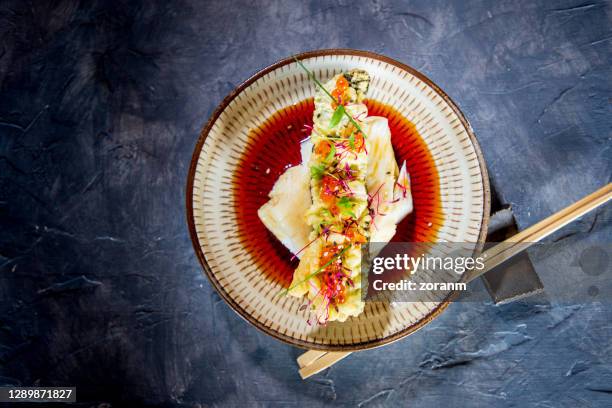 directly above sea bass fillet with tempura stick on top in soy sauce - bacalhau imagens e fotografias de stock