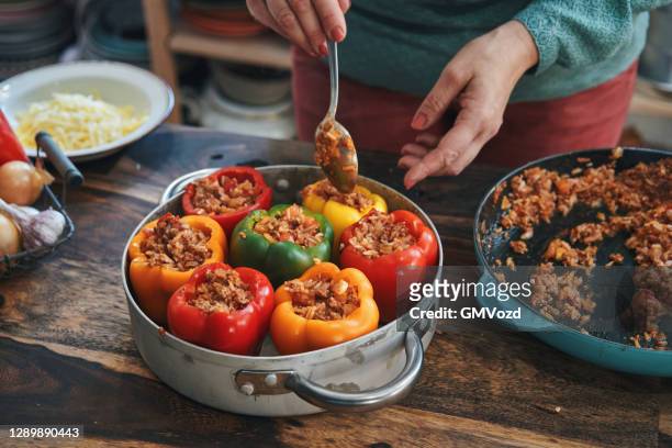 preparing stuffed bell peppers with ground meat in tomato sauce - paprika stock pictures, royalty-free photos & images