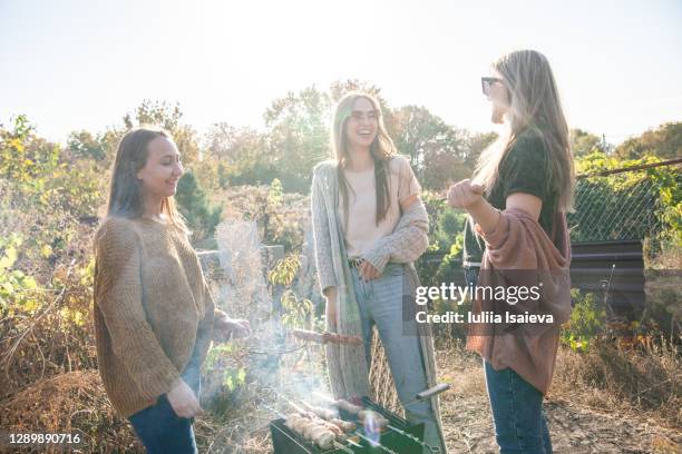 happy girlfriends grilling skewers in yard - talking friends backlight stock pictures, royalty-free photos & images