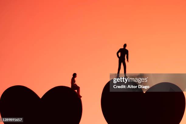 concept of love: a man and a woman each on the silhouette of a heart. - long distance relationship stock pictures, royalty-free photos & images