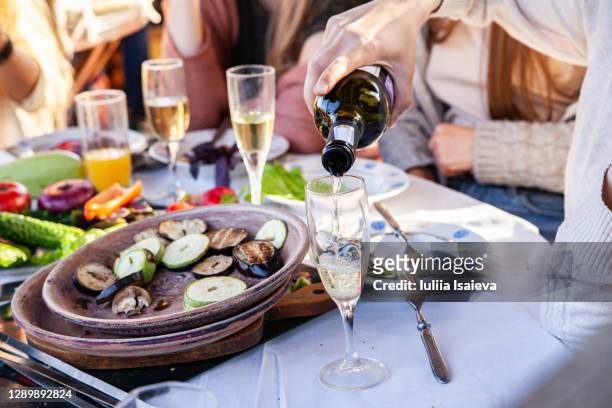 crop person pouring wine during barbecue - harvest table stock-fotos und bilder