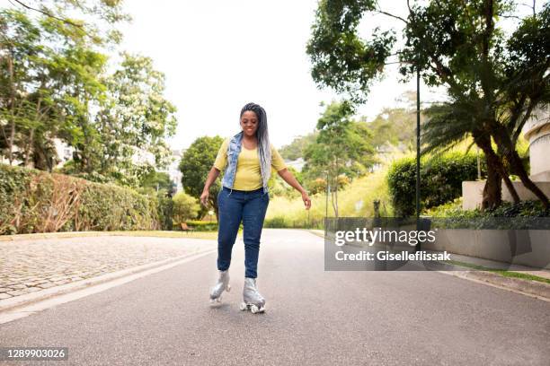 mujer negra patinando al aire libre en una calle - patín en línea fotografías e imágenes de stock