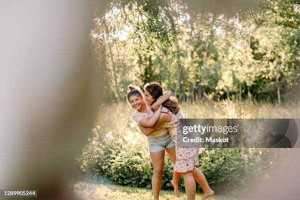 portrait of happy girl embracing sibling in backyard - weißes kleid stock-fotos und bilder