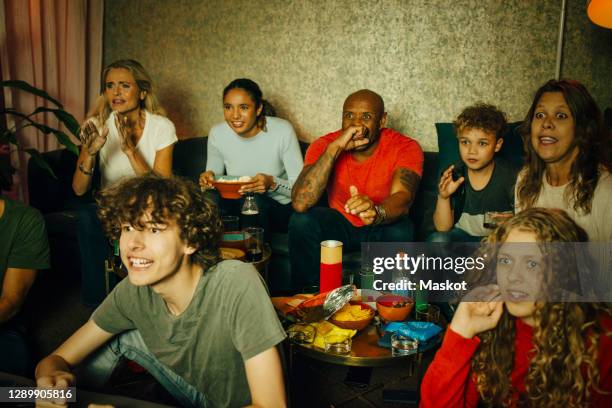 sports fans watching tv together at night - family game night stock pictures, royalty-free photos & images