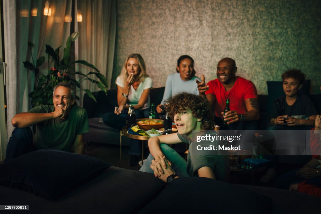 Smiling friends and family watching sports at night