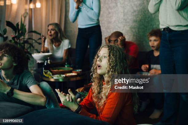 disappointed family watching sports on tv at night - delusione foto e immagini stock