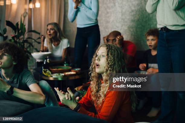 disappointed family watching sports on tv at night - people watching tv stock pictures, royalty-free photos & images