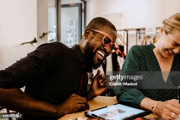 cheerful employee and female owner working while using digital tablet in store - fashion store staff stock pictures, royalty-free photos & images