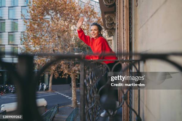 femme à la terrasse saluant des voisins pendant le séjour covid-19 à la commande à la maison - neighbours photos et images de collection