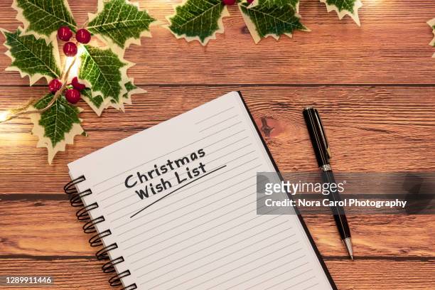christmas wish list text on note pad with christmas light garland - christmas list stock-fotos und bilder