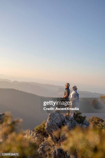 rijpe paarwandelingen langs zonnige bergkam in de ochtend - man woman top view stockfoto's en -beelden