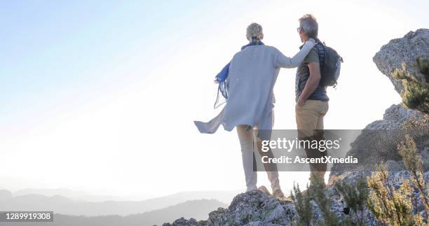 mature couple relaxes on sunny mountain ridge in the morning - woman finding grey hair stock pictures, royalty-free photos & images