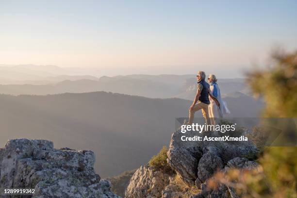 rijpe paarwandelingen langs zonnige bergkam in de ochtend - man woman top view stockfoto's en -beelden