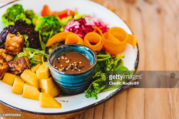 delicious food bowl with tofu, black rice, kale, beetroot, mango and a sesame tahini dressing - tofu stock pictures, royalty-free photos & images